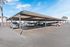 Modern covered parking area with multiple parked vehicles under a bright blue sky, enhancing convenience and protection.