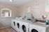 Bright and efficient laundry room equipped with multiple modern washing machines, promising convenience and ease.