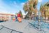 Inviting playground with vibrant climbing structures and slides, surrounded by lush trees and modern apartments, perfect for family-friendly living.