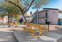 Beautiful apartment complex with vibrant outdoor picnic area, featuring bright yellow tables and lush trees, offering a welcoming community space.