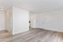 Bright and spacious open-plan living area with stylish wood flooring, modern kitchen access, and ample natural light.