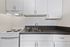 Sleek modern kitchen featuring white cabinetry, stainless steel sink, and electric stove.
