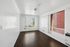 Bright, airy room with large windows and sleek wooden flooring, showcasing a modern, minimalist style.