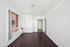Bright and inviting room with elegant dark wood floors, large window for natural light, and an archway leading to adjoining spaces.