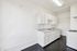 Bright, modern kitchen with sleek white cabinetry and polished black flooring.
