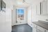 Bright utility room with sleek white cabinetry, a large window inviting natural light, and modern electrical features.
