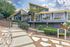 Stunning contemporary apartment building with bold architecture and spacious windows, surrounded by lush greenery and stylish landscaping.