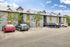 Charming apartment complex featuring modern architecture, ample parking, and vibrant landscaping under a clear blue sky.
