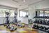 Bright and modern gym with ellipticals, mirrored walls, and a full range of free weights, perfect for energizing workouts.