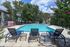 Inviting outdoor pool area with comfortable lounge chairs and vibrant greenery, perfect for relaxation and leisure in a sunny setting.