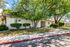 Charming white stucco home surrounded by lush greenery, offering a serene and inviting atmosphere.