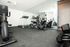 Modern fitness center with sleek exercise equipment, large mirror wall, and natural lighting.