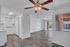 Bright open-concept apartment with a modern kitchen and elegant wood flooring. Features a spacious living area with large windows and a ceiling fan, inviting abundant natural light.