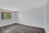 Bright, empty room with modern wood flooring and a large window, offering a blank canvas for personalized design.
