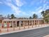 Charming apartment complex with two-story buildings, surrounded by a peaceful neighborhood and clear blue sky backdrop.