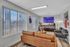 Inviting leasing office lounge with sleek leather sofa, modern decor, and bright windows overlooking cityscape.