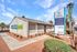 Charming exterior of Nellis Gardens leasing office with well-maintained landscaping and prominent signage showcasing newly renovated 1, 2, and 3-bedroom apartments.