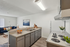 Beautifully staged apartment showcasing a modern open kitchen with sleek countertops and elegant decor, leading to a stylish living area with cozy seating and contemporary artwork.