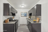 Modern kitchen with sleek dark cabinets, granite countertops, and stylish backsplash, featuring stainless steel appliances and elegant staging.