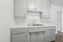 Modern kitchen with sleek white cabinetry and dual stainless steel sink, offering ample storage and functionality.