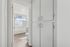 Bright modern bathroom with crisp white cabinetry, enclosed shower, and wood-style flooring, offering a sleek and refreshing ambiance.