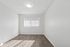 Bright, minimalist room with elegant wooden flooring and a large window featuring vertical blinds, perfect for a cozy setup.