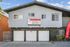 Charming apartment building with stone accents and large garage doors, featuring a prominent banner inviting visitors to schedule appointments at Westland @ Daisy for premier living solutions.