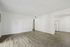 Modern apartment with sleek hardwood floors, open living space, and an inviting entryway to the kitchen.
