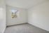 Bright and airy bedroom with plush carpeting and a large window offering charming outdoor views.
