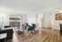 Bright and inviting living room with cozy seating, elegant hardwood floors, and access to a sunlit balcony in a modern apartment.