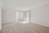 Bright and airy living space with plush carpet and natural light flowing through large windows, perfect for comfortable living.