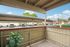 Charming private balcony with a view of a tranquil parking area and lush greenery, perfect for relaxation.