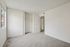 Bright and airy bedroom featuring large window, spacious closet, and soft carpeting, perfect for modern living.