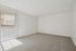 Bright, spacious room with plush carpet and large sliding glass doors offering natural light and an inviting atmosphere.