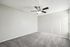 Bright and inviting bedroom with plush carpet, modern ceiling fan, and ample natural light streaming through large windows.