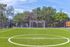 Inviting sports complex featuring a pristine soccer field with vibrant green turf and surrounding trees, perfect for outdoor activities.