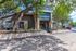 Charming leasing center with stone accents and lush trees creating a welcoming entrance.