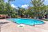 Charming outdoor pool area surrounded by lush greenery and comfortable lounging chairs, perfect for relaxation and leisure.