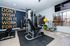 Inviting home gym with modern equipment, motivational wall quote, ample natural light, and sleek decor, perfect for energizing workouts.