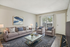 Modern living room with elegant decor, featuring a cozy gray sofa, stylish armchairs, and a chic glass coffee table on a patterned rug.