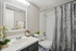 Modern, virtually staged bathroom with elegant fixtures, stylish vanity, and a chic shower curtain, creating a fresh and inviting atmosphere.