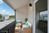 Charming balcony with cozy rattan seating and vibrant cushions, offering a perfect spot to relax and enjoy the neighborhood view.