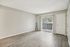 Bright and airy room with sleek wood flooring, large sliding glass doors opening to a patio, and welcoming neutral tones.