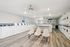 Spacious apartment laundry room featuring modern washers and dryers, sleek flooring, and comfortable seating area.
