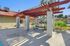 Inviting outdoor patio featuring a stylish pergola and modern picnic table, perfect for relaxation in a sunny courtyard.