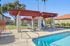 Inviting poolside oasis with stylish pergola and modern lounge chairs, perfect for relaxation and leisure.