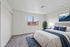 Inviting bedroom with modern decor, a cozy bed with blue accents, natural light, and a scenic view.
