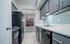 Contemporary kitchen with sleek black appliances, ample cabinetry, and stylish mint subway tile backsplash.