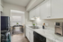Bright, virtually staged kitchen with sleek white cabinets, modern appliances, and an inviting dining area with chic table settings.
