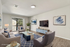 Elegant living room showcasing modern design, featuring plush seating, a sleek TV, and abundant natural light from a large window with scenic views.